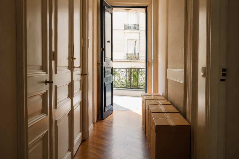 Cartons alignés dans l'entrée d'un appartement, prêts à sortir