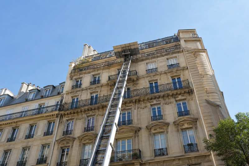 Monte-meuble déployé le long d'une façade haussmannienne